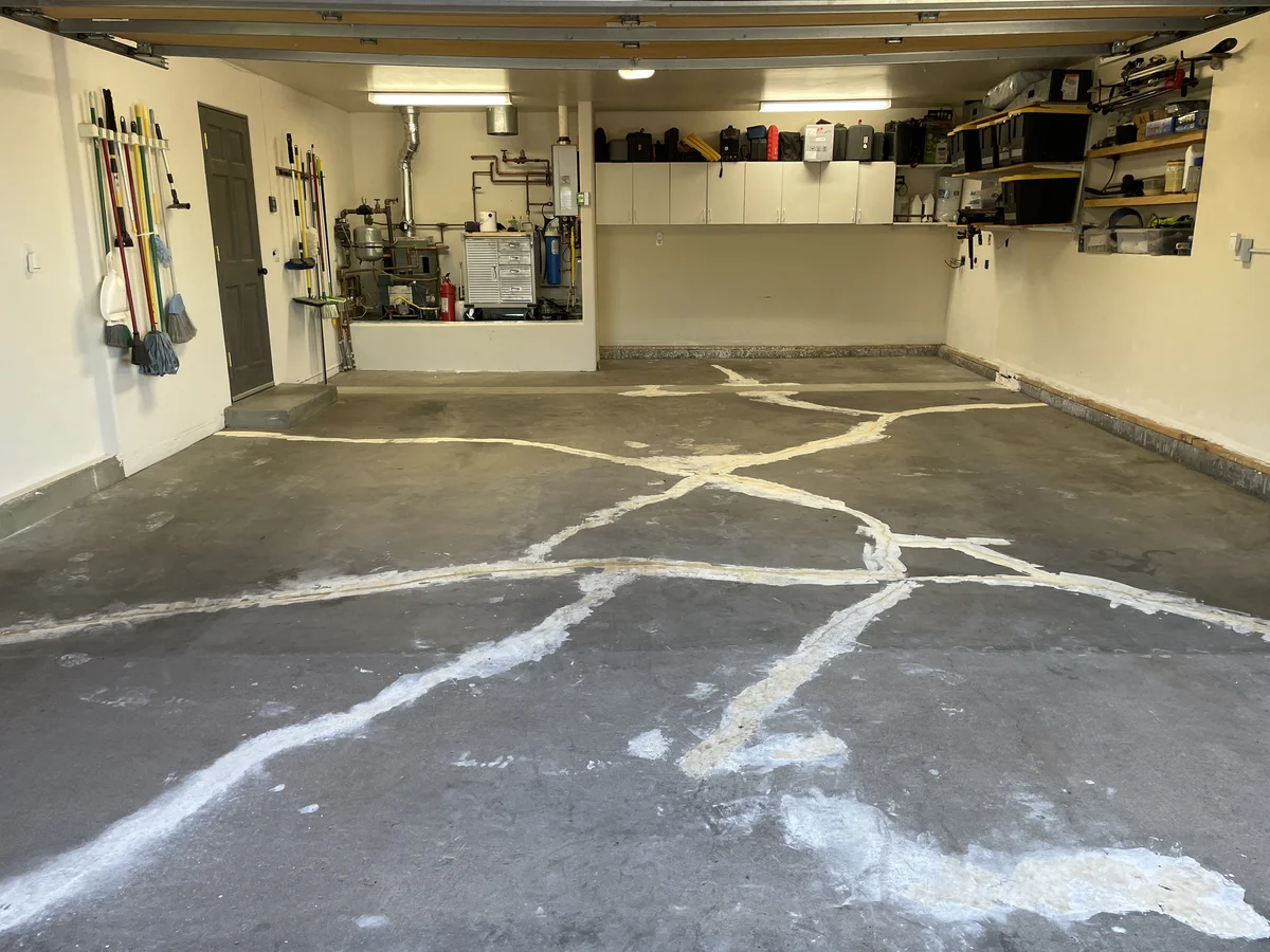 Bare concrete garage floor before epoxy coating installation in Albuquerque, NM — cracked and stained unfinished surface