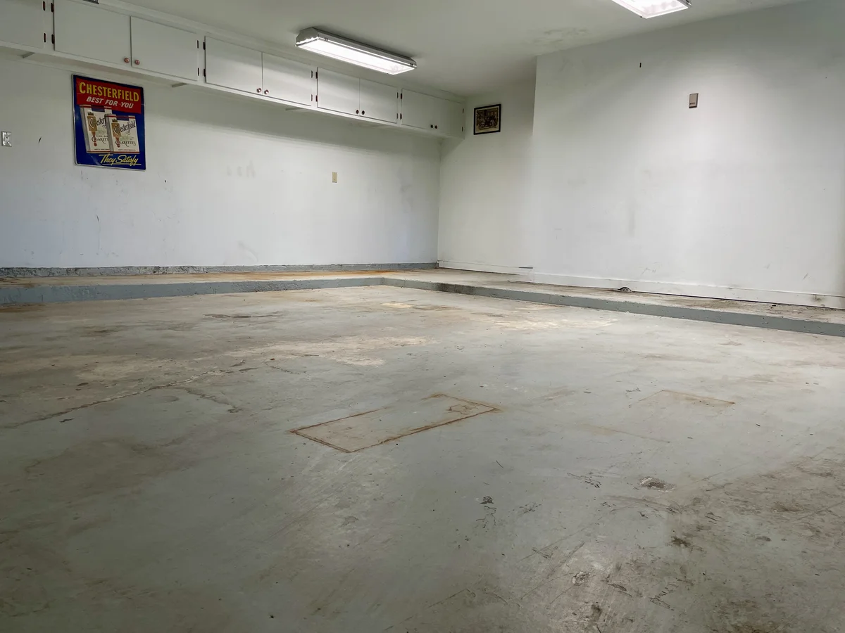 Bare concrete garage floor before epoxy coating installation in Santa Fe, NM — rough and stained unfinished surface