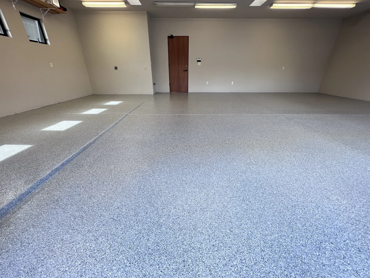 Charcoal flake epoxy garage floor with a high-gloss polyaspartic finish, completed in a Santa Fe, NM residential garage